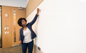 Eine Person schreibt an der Tafel